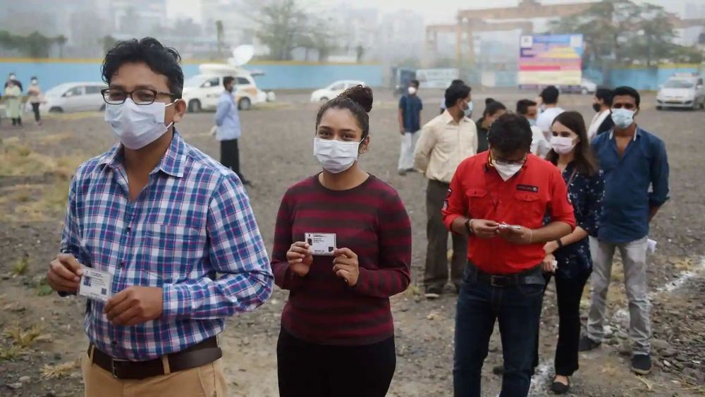 Volunteers stand in a queue outside a vaccination unit during the dry run of the Covid-19 vaccine at a center in Mumbai. (PTI)